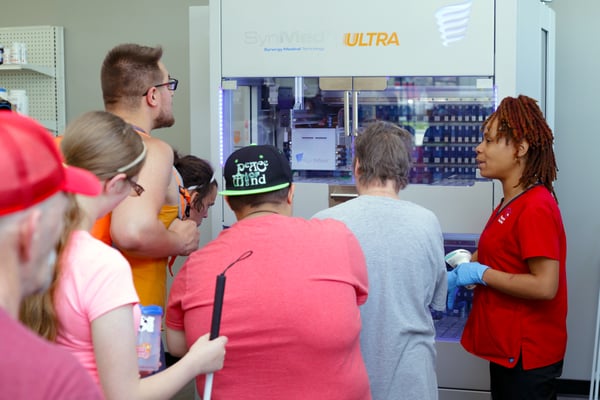 Neighborhood LTC Pharmacy Tech Demonstrating Medication Filler Robot